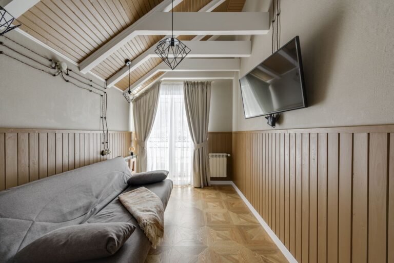 Przytulny salon z kanapą i telewizorem na ścianie